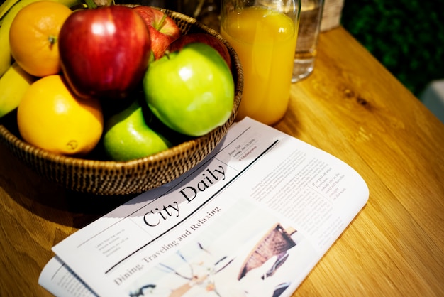 Fruits newspaper and juice on kitchen counter