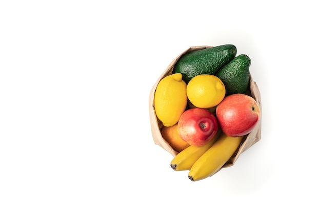 Fruits in a paper bag are isolated on a white background.