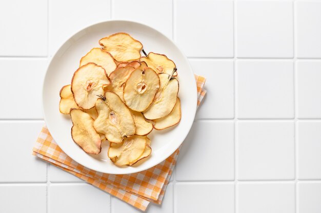 Fruits pear chips on a white modern background vegan dessert sugar free