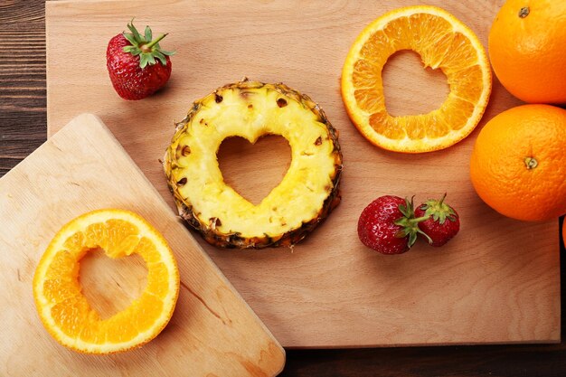 Ломтики фруктов с нарезкой в форме сердца и ягоды на столе крупным планом