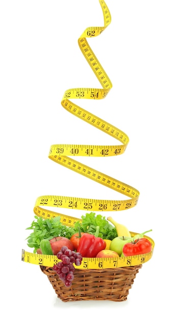 Fruits and vegetables in a basket with a measure tape around it