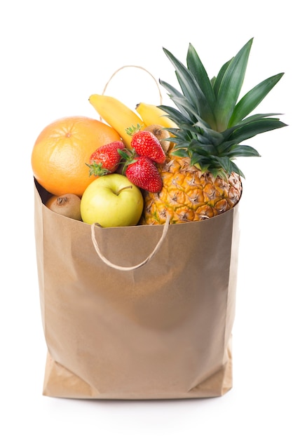Fruits and vegetables in paper grocery bag isolated over white