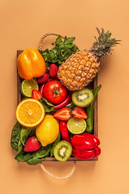 Фрукты и овощи, богатые витамином С, в коробке. Здоровое питание. Вид сверху