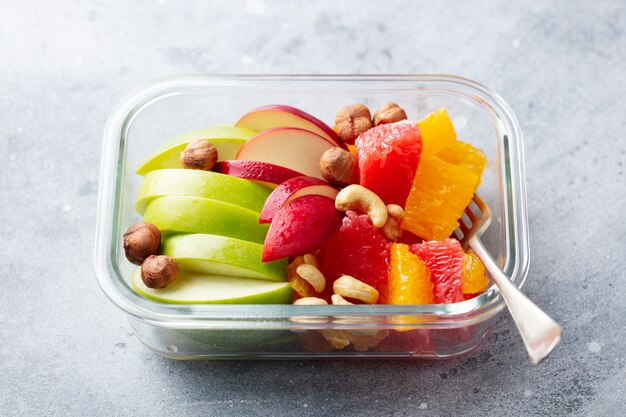 Fruitsalade en noten in een glazen container. Gezond eten.