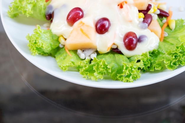 Fruitsalade in een witte schotel.