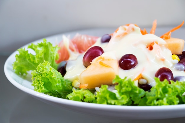 Fruitsalade in een witte schotel.