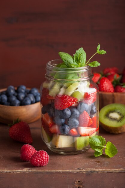 Fruitsalade in mason jar aardbei bosbessen kiwi appel munt