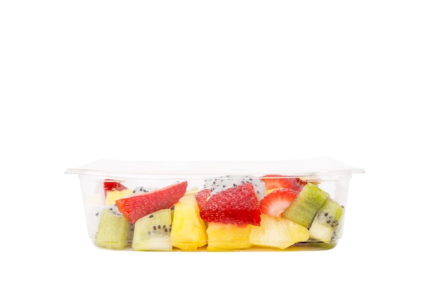 Fruitsalade van ananas, aardbeien, kiwi en pitahaya in een plastic container op een witte achtergrond