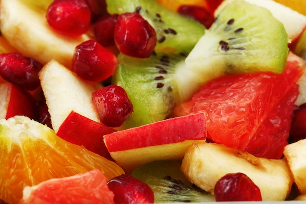 Fruitsaladeclose-up in volledig scherm, als achtergrond. Plakjes vers en gezond fruit voor een gezond dieet.