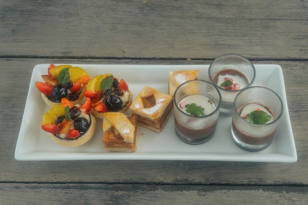 Fruittaartjes, appeltaart, chocoladepuddingkeuken met grijze houten achtergrond