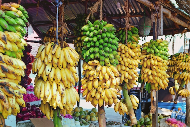 Fruitwinkel op Sri Lanka Street met verschillende producten en grote takken met bananen. Landbouwproducten in Azië.