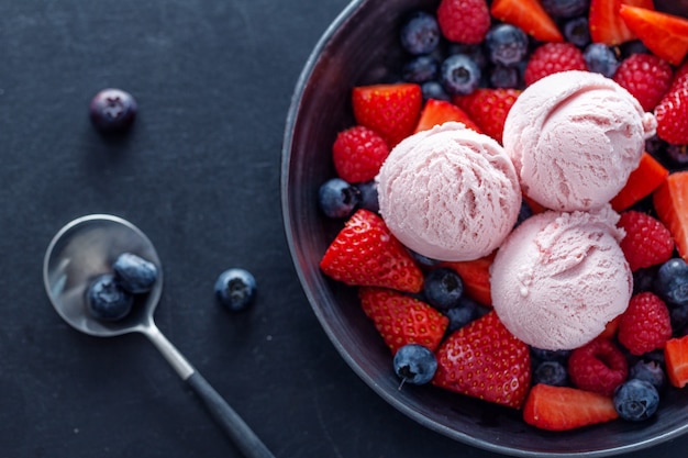 Fruity strawberry Ice cream scoops served on plate with fruits. Closeup