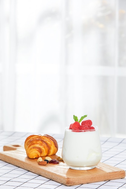 Fruityoghurt en croissants op tafel voor het raam