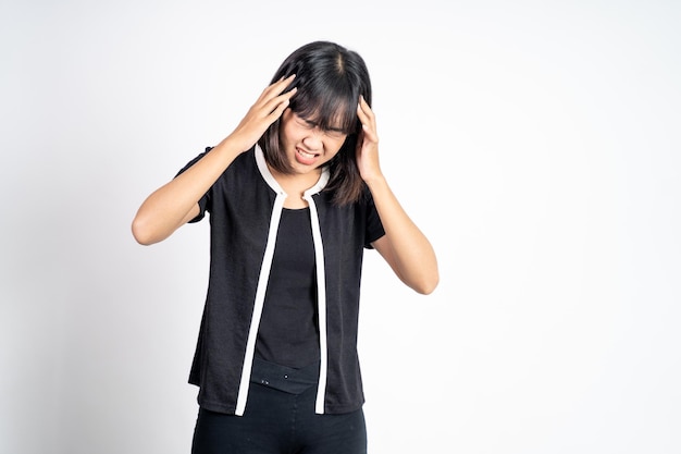 Frustrated asian young woman holding head with headache