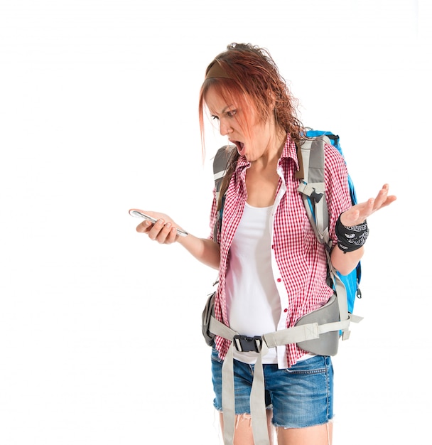 Frustrated backpacker talking to mobile over white background