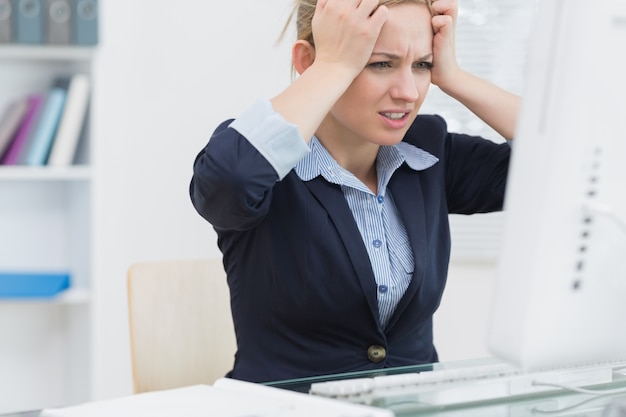 Photo frustrated business woman in front of computer at office desk