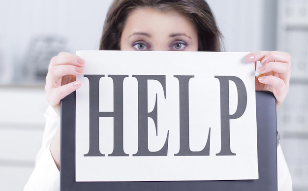 Frustrated business woman showing a sheet with the word help