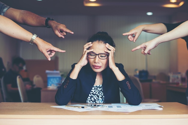 Frustrated business woman sitting at the table in office