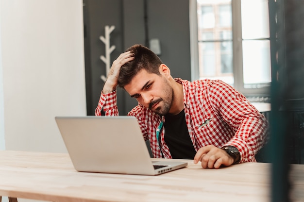 Premium Photo | Frustrated businessman sitting on desk with hand on ...