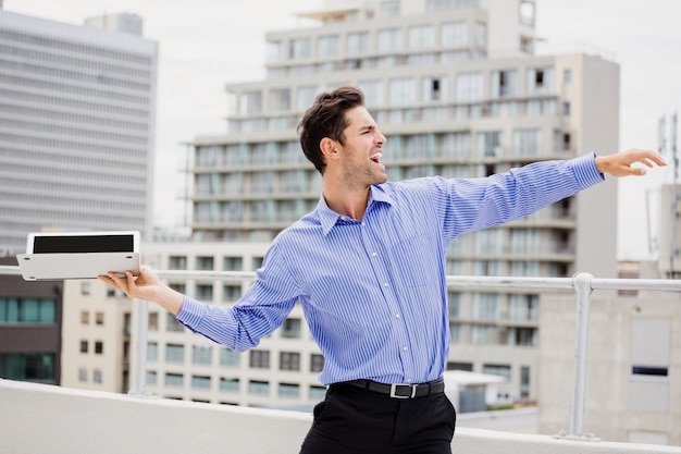 Frustrated businessman throwing laptop