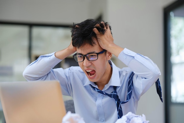 frustrated businessman yelling at laptop in anger