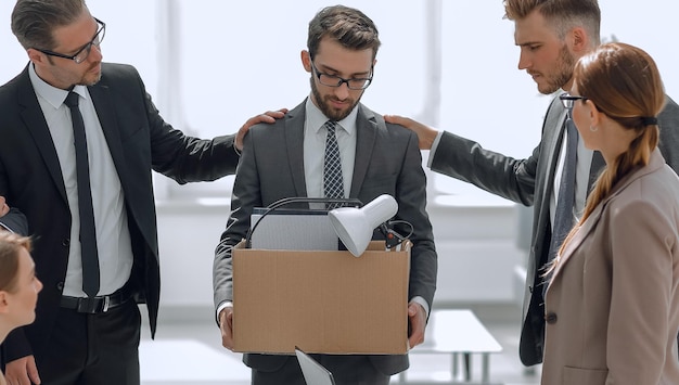 Frustrated employee with personal things standing in\
office