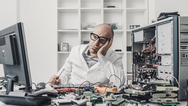 Foto tecnico esausto frustrato che ripara un computer