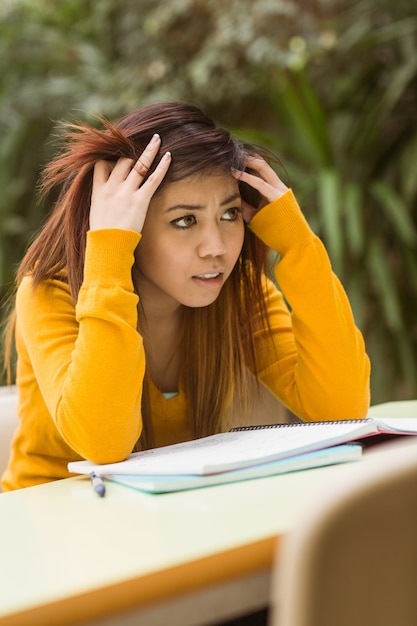 Frustrated female college student doing homework