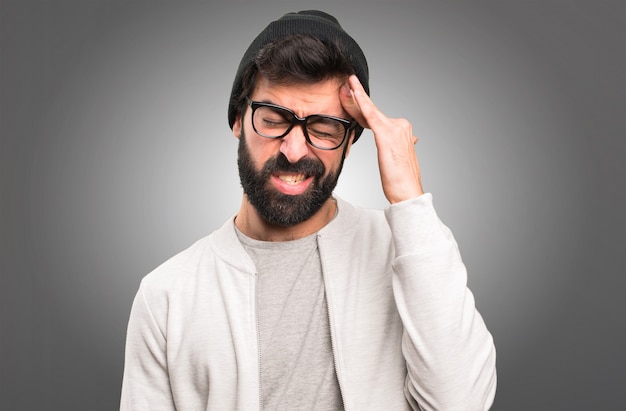 Frustrated hipster man on grey background