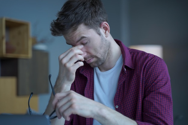 Frustrated male Austrian entrepreneur tired of remote work online sitting at modern home office