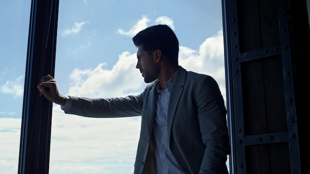 Frustrated man silhouette leaning window closeup Ceo considering business alone