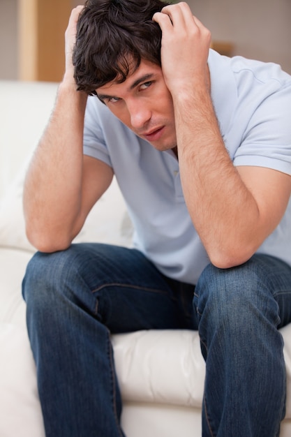 Frustrated man sitting on the sofa