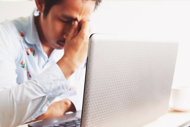 Photo frustrated man with laptop at desk