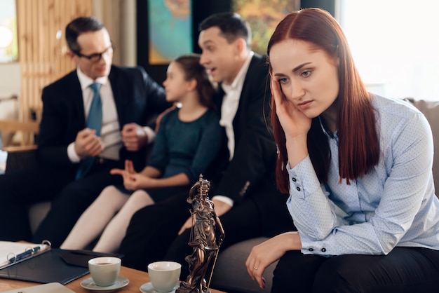 Frustrated redhead mother in blue shit sits on couch 