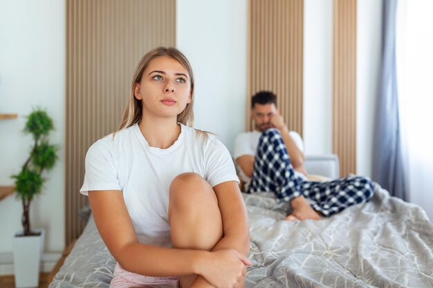 Photo frustrated sad girlfriend sit on bed think of relationship problems thoughtful couple after quarrel lost in thoughts upset lovers consider break up offended person disappointed by boyfriend