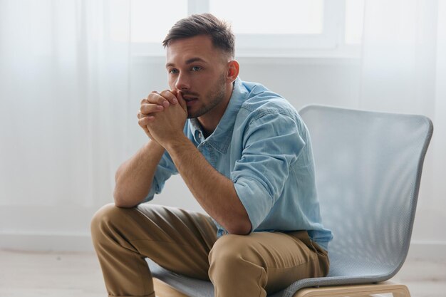 Frustrated tired sad young handsome man folded arms looks aside
can not make important decision in life sitting at home upset guy
need professional psychology help have depression problems
concept