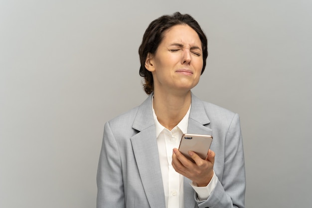 Frustrated woman hold phone crying, stunned with bad negative news disciplinary action and dismissal