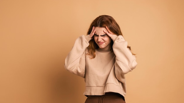 Фото Разочарованная женщина с головной болью в коричневой студии