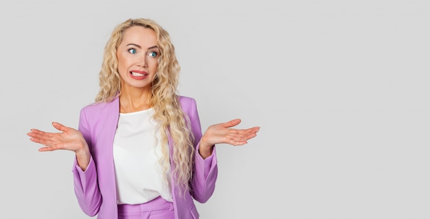 Frustrated woman, upset, bewildered Caucasian pretty blond woman shrugs, arms outstretched, complete disbelief to doubt