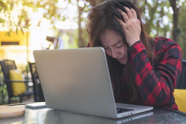 사진 야외 카페에 앉아있는 손에 머리를 들고 좌절한 여성