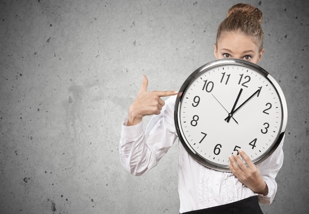 Frustrated young businessman holding an alarm clock