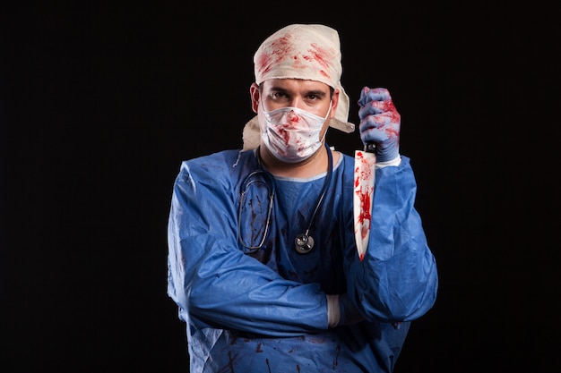 Frustrated young doctor looking with serious at the camera. Man dressed as a nutcase doctor for halloween.