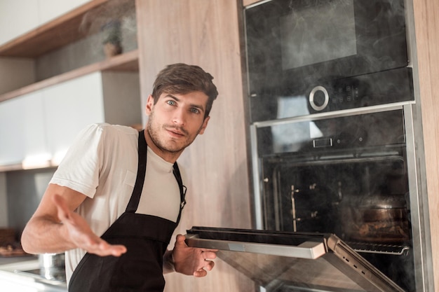 Frustrated young man standing near broken oven