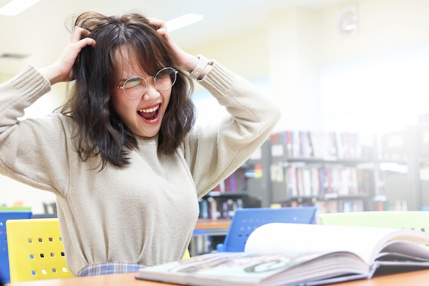 写真 図書館に座っている落胆した若い女性