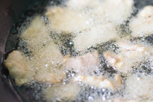 Fry the pork in boiling oil in a black pan.