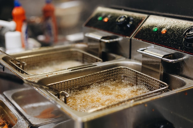 Frying chicken nuggets in deep fryer Restaurant meal preparation