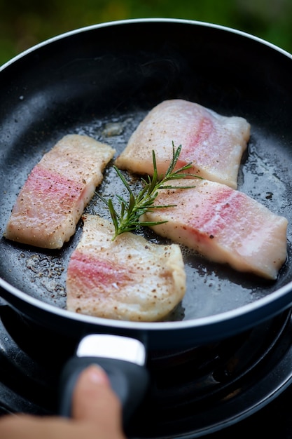 Frying fish in cooking pan