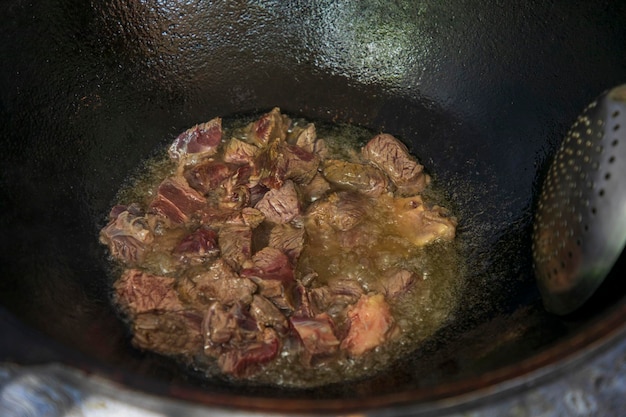 frying meat in a oil pan