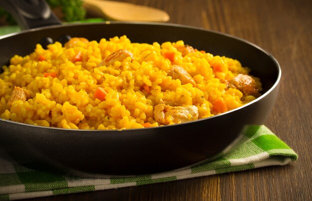 Frying pan full of rice on wooden