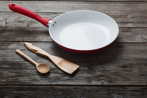 Frying pan on old wooden background